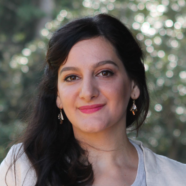 Reem Bailony, a young white woman with long dark hair, wearing hoop earrings and a light colored stop.